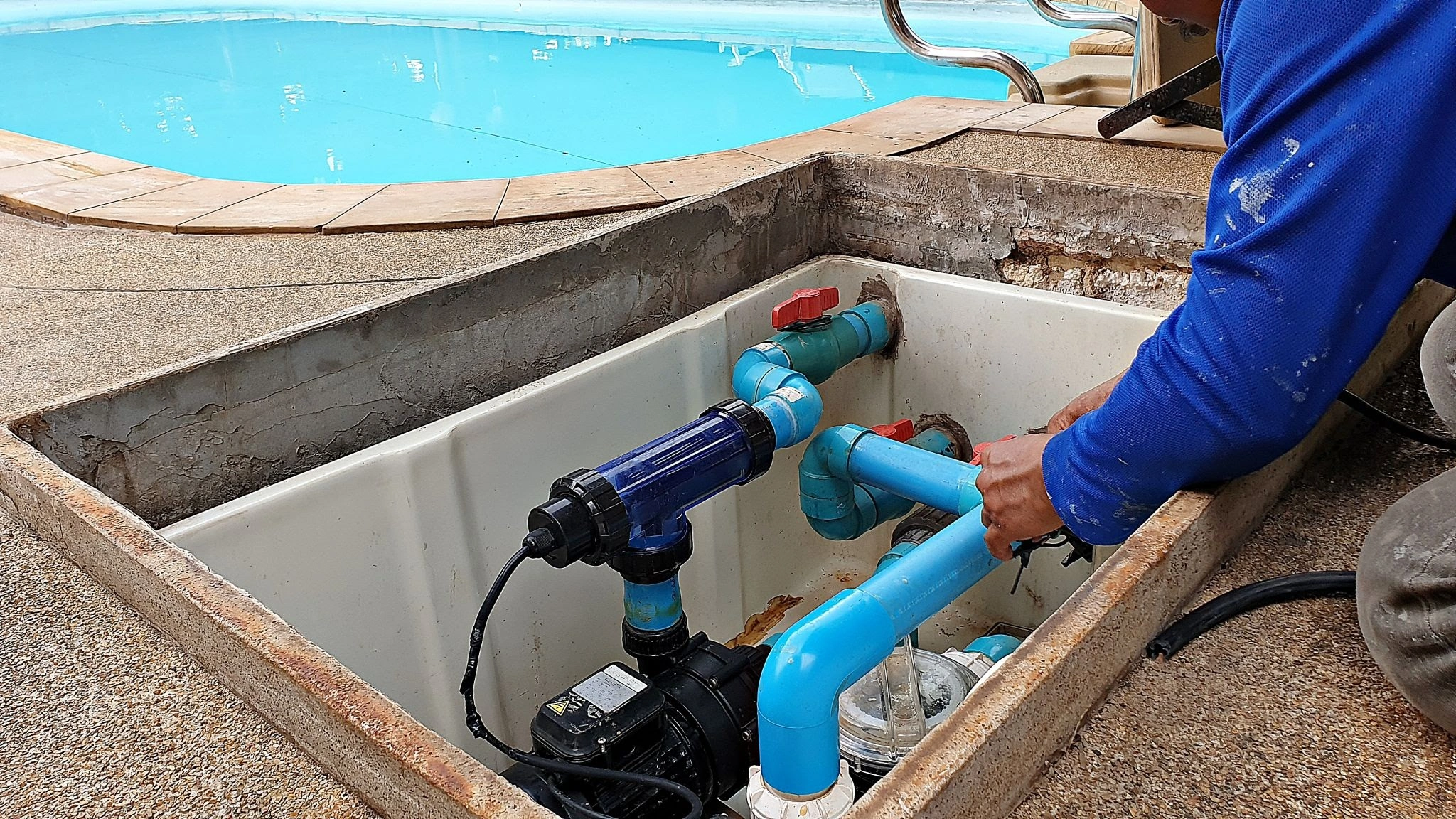 Technician installing a saltwater chlorinator and pool equipment